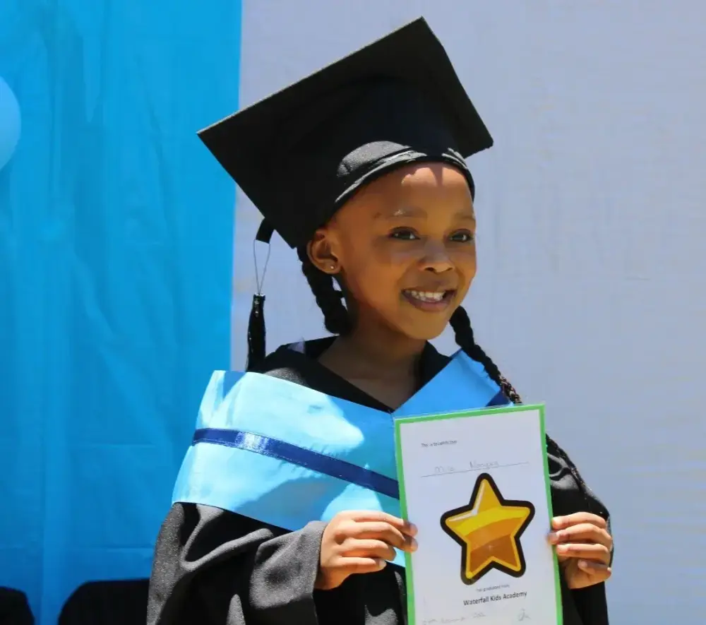 A proud Waterfall Kids Academy Grade R graduate with her certificate